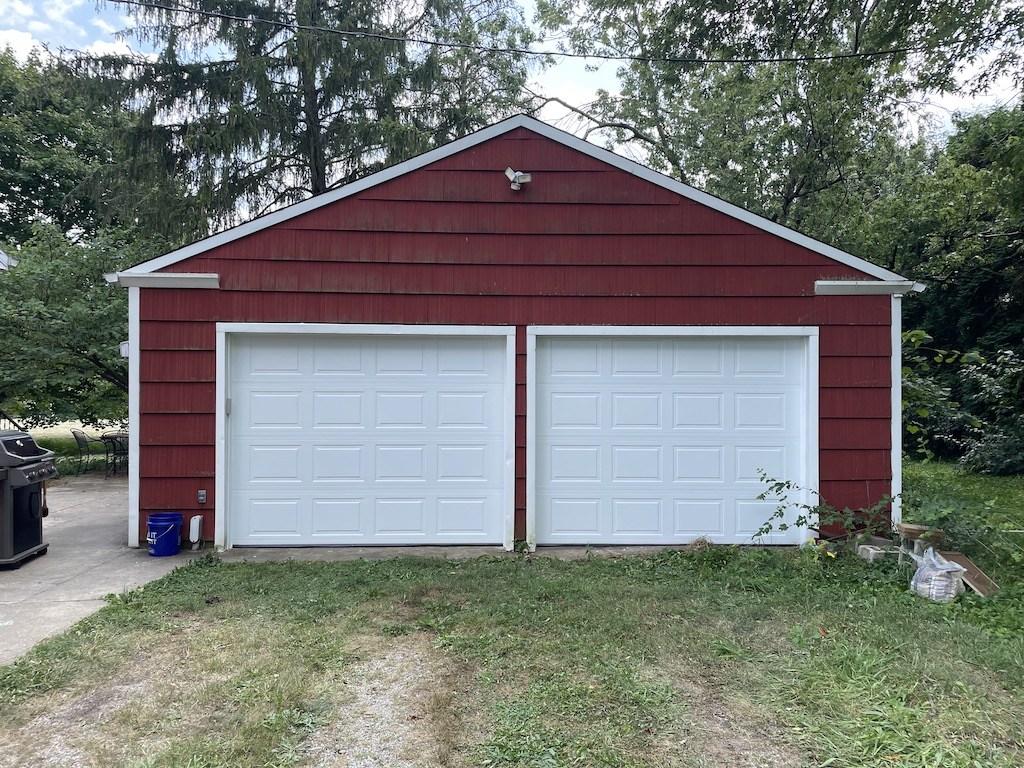two white garage doors on red building